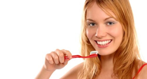 Beautiful girl about to brush her teeth, close up, isolated on white