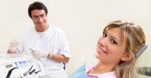 young woman doing dental checkup. Dentist in the background